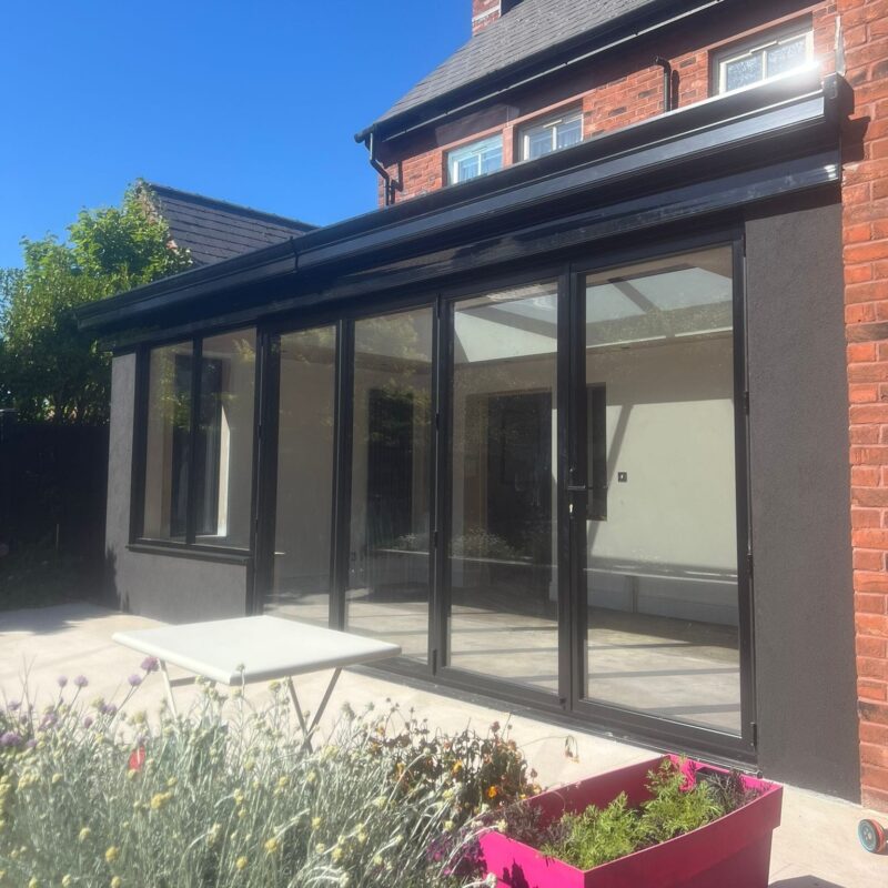 HUP Orangery with black smooth render, aluminium windows, and bi folding doors