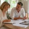 Couple planning kitchen extension at home desk