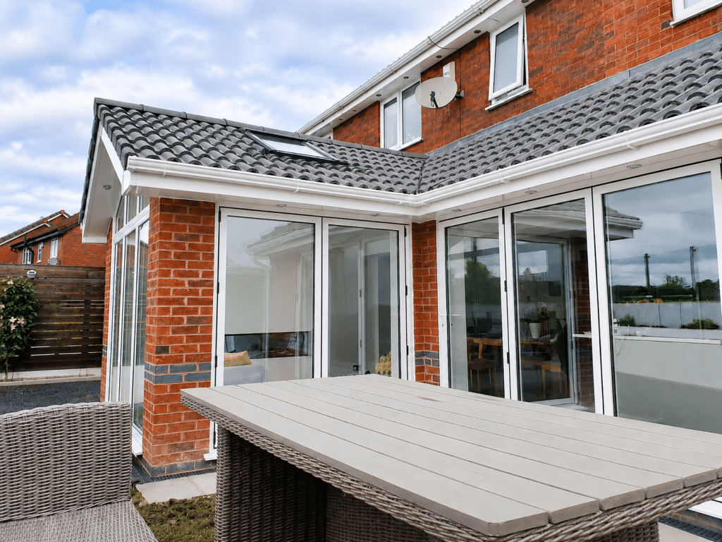 Single-storey brick rear extension in St Helens with a tiled roof, rooflight and large white-framed patio doors.