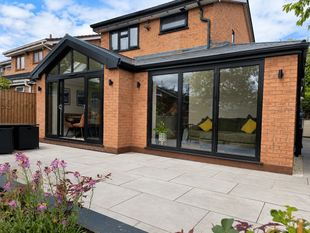 Gable fronted Wrap round extension with Black Bi-folding Doors and a 4 pane patio