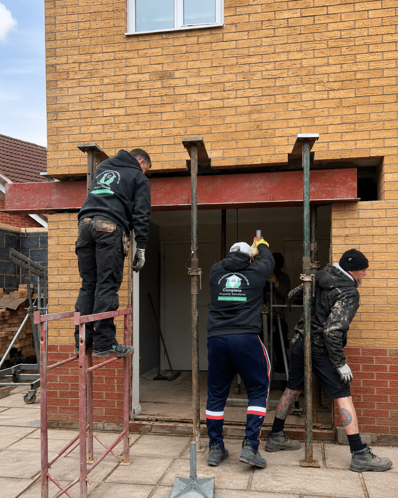 Steel beam being installed at the rear of a house to create a larger opening for new bi-folding doors.