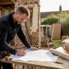 Builder measuring timber guide on Haydock extension site