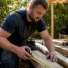 Builder measuring timber on site