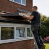 Builder fitting conservatory roof panel outdoors