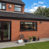 Completed wrap-around extension in St Helens with matching brickwork, tiled roof and new windows and French doors.
