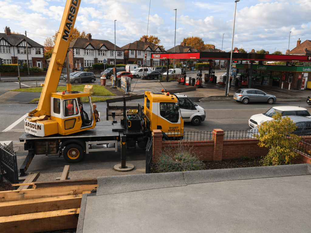 Steel beam being delivered by crane for a house extension.